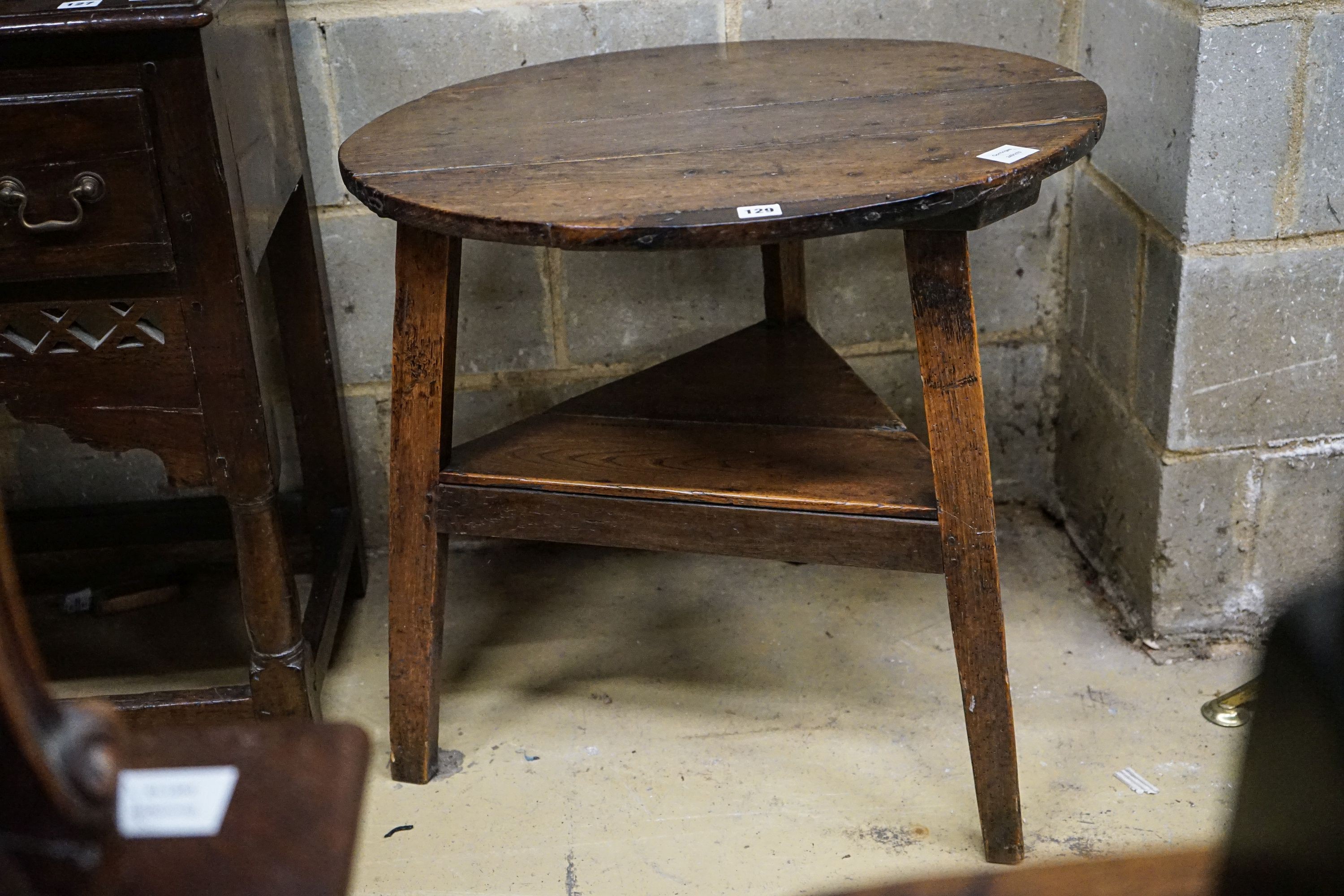 A George III oak cricket table, with circular top and triangular understage, diameter 67cm, height 65cm